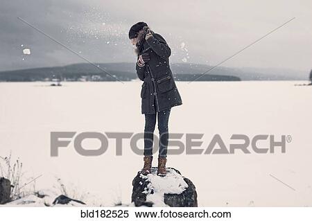 Stock Photography - Caucasian teenage girl dodging snowballs. Fotosearch