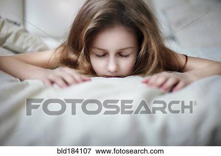 Stock Photo - Caucasian teenage girl laying on bed. Fotosearch