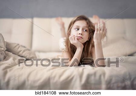 Stock Photo - Caucasian teenage girl laying on bed. Fotosearch