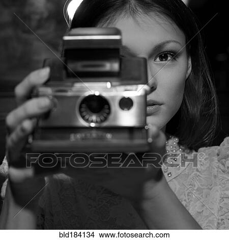 Picture - Caucasian teenage girl photographing with instant camera. Fotosearch