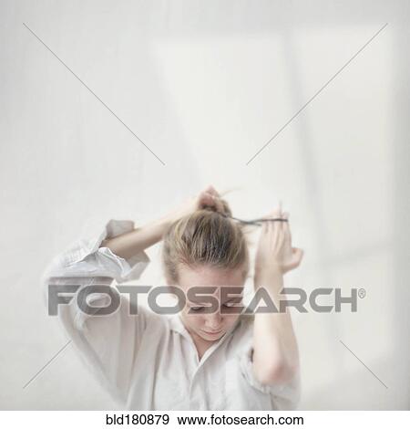 Caucasian teenage girl tying her hair into bun View Large Photo Image Stock Photo - Caucasian teenage girl tying her hair into bun. Fotosearch