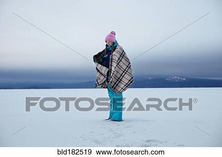 Stock Photo - Caucasian teenage girl wrapped in blanket in snow. Fotosearch