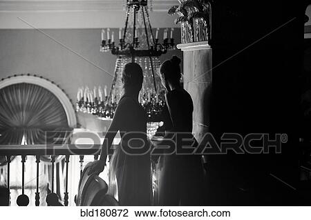 Stock Image - Caucasian teenage girls looking over balcony. Fotosearch