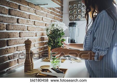 Stock Photo - Caucasian woman arranging flowers. Fotosearch