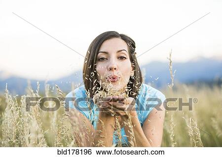 Caucasian woman blowing seeds in field View Large Photo Image Stock Photograph - Caucasian woman blowing seeds in field. Fotosearch