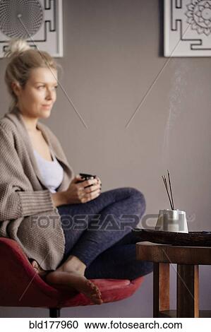 Caucasian woman burning incense in living room View Large Photo Image Stock Image - Caucasian woman burning incense in living room. Fotosearch