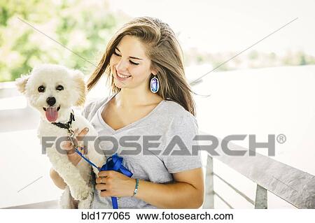 Stock Photography - Caucasian woman carrying dog outdoors. Fotosearch