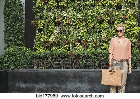 Stock Photo - Caucasian woman carrying purse outdoors. Fotosearch