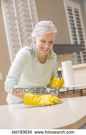 Caucasian woman cleaning kitchen countertop View Large Photo Image Picture - Caucasian woman cleaning kitchen countertop. Fotosearch
