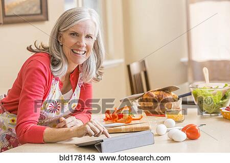 Caucasian woman cooking in kitchen View Large Photo Image Stock Image - Caucasian woman cooking in kitchen. Fotosearch
