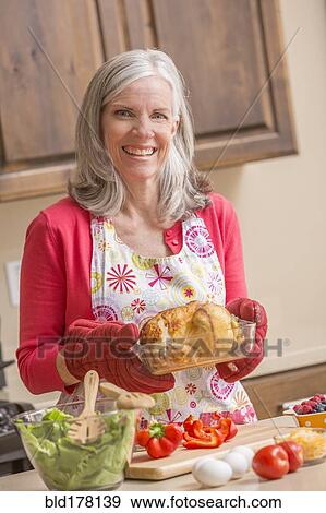 Stock Photo - Caucasian woman cooking in kitchen. Fotosearch