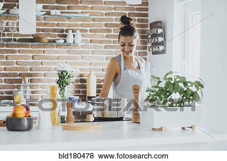 Stock Photo - Caucasian woman cooking in kitchen. Fotosearch