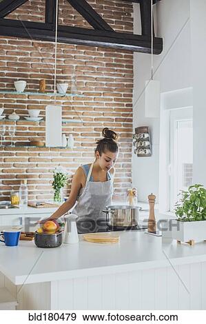 Stock Photo - Caucasian woman cooking in kitchen. Fotosearch