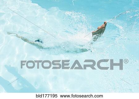 Stock Photography - Caucasian woman diving in swimming pool. Fotosearch