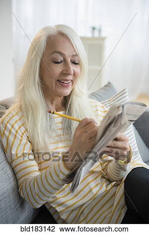 Caucasian woman doing crossword puzzle View Large Photo Image Stock Image - Caucasian woman doing crossword puzzle. Fotosearch