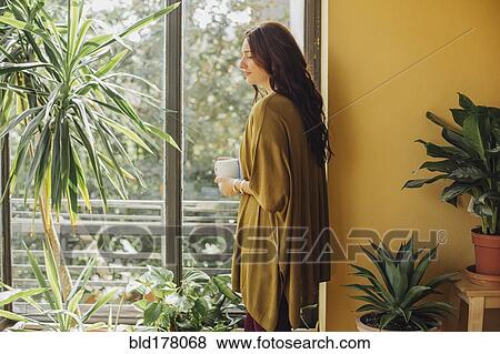 Stock Photo - Caucasian woman drinking cup of coffee. Fotosearch