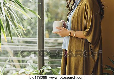 Stock Photo - Caucasian woman drinking cup of coffee. Fotosearch