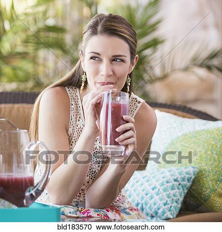 Stock Image - Caucasian woman drinking juice. Fotosearch