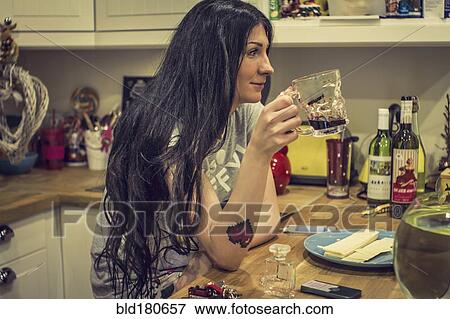 Stock Photo - Caucasian woman drinking tea in kitchen. Fotosearch