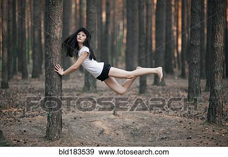 Caucasian woman floating in forest View Large Photo Image Stock Photo - Caucasian woman floating in forest. Fotosearch
