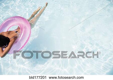Caucasian woman floating in swimming pool View Large Photo Image Stock Image - Caucasian woman floating in swimming pool. Fotosearch