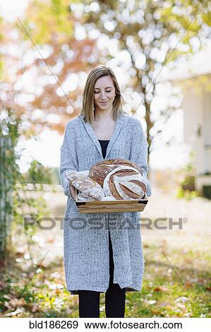 Caucasian woman holding bread outdoors View Large Photo Image Stock Photo - Caucasian woman holding bread outdoors. Fotosearch