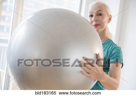 Stock Photography - Caucasian woman holding fitness ball. Fotosearch