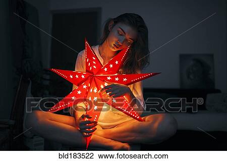 Stock Image - Caucasian woman holding glowing lantern. Fotosearch