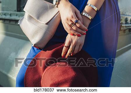 Stock Photo - Caucasian woman holding hat and purse. Fotosearch