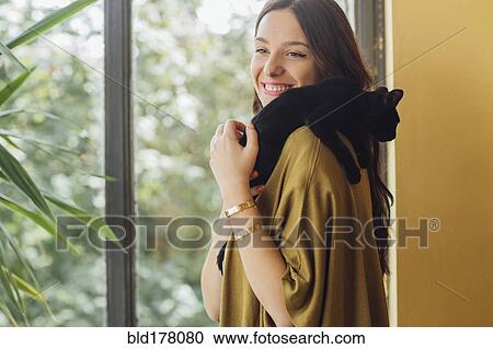 Stock Image - Caucasian woman holding kitten. Fotosearch