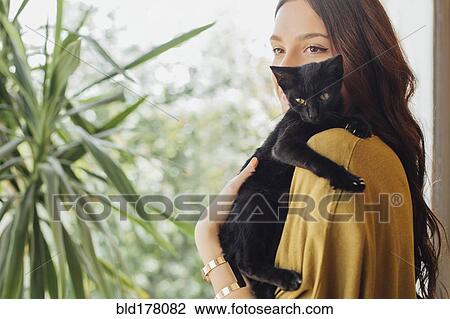 Stock Image - Caucasian woman holding kitten. Fotosearch