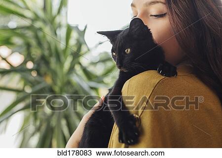 Stock Image - Caucasian woman holding kitten. Fotosearch