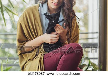 Stock Photo - Caucasian woman holding kitten. Fotosearch