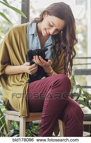 Stock Photograph - Caucasian woman holding kitten. Fotosearch