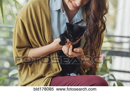 Stock Photography - Caucasian woman holding kitten. Fotosearch