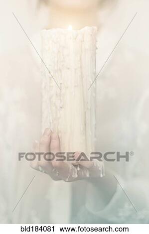 Stock Image - Caucasian woman holding melting candle. Fotosearch