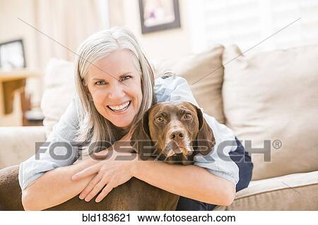 Caucasian woman hugging dog on sofa View Large Photo Image Stock Image - Caucasian woman hugging dog on sofa. Fotosearch
