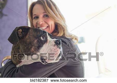 Stock Photo - Caucasian woman hugging dog. Fotosearch
