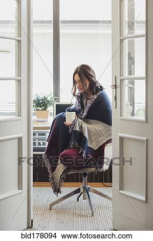 Caucasian woman in blanket drinking cup of coffee View Large Photo Image Picture - Caucasian woman in blanket drinking cup of coffee. Fotosearch
