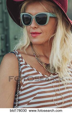Stock Image - Caucasian woman in hat and sunglasses. Fotosearch