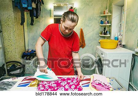 Picture - Caucasian woman ironing laundry. Fotosearch