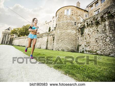 Stock Image - Caucasian woman jogging outdoors. Fotosearch