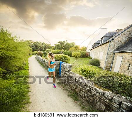 Stock Image - Caucasian woman jogging outdoors. Fotosearch