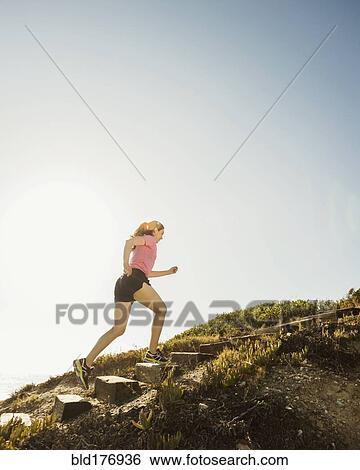 Stock Photograph - Caucasian woman jogging uphill. Fotosearch