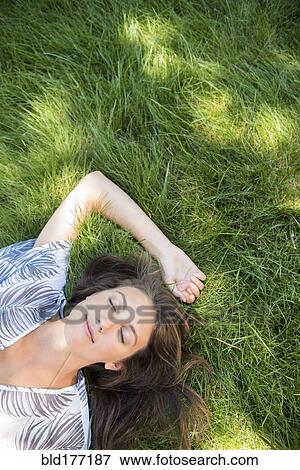 Stock Photo - Caucasian woman laying in grass. Fotosearch