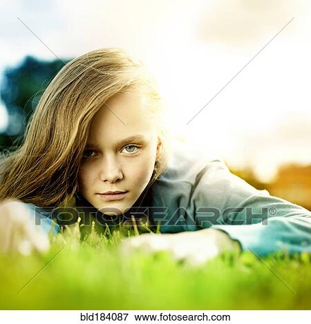 Stock Photo - Caucasian woman laying in grass. Fotosearch
