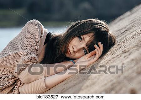 Caucasian woman laying on sand View Large Photo Image Stock Photo - Caucasian woman laying on sand. Fotosearch