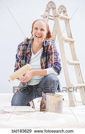 Caucasian woman painting in new home View Large Photo Image Stock Photo - Caucasian woman painting in new home. Fotosearch