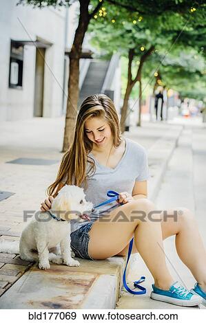 Caucasian woman petting dog on sidewalk View Large Photo Image Stock Photo - Caucasian woman petting dog on sidewalk. Fotosearch