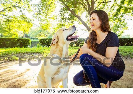 Caucasian woman petting dog outdoors View Large Photo Image Stock Photography - Caucasian woman petting dog outdoors. Fotosearch
